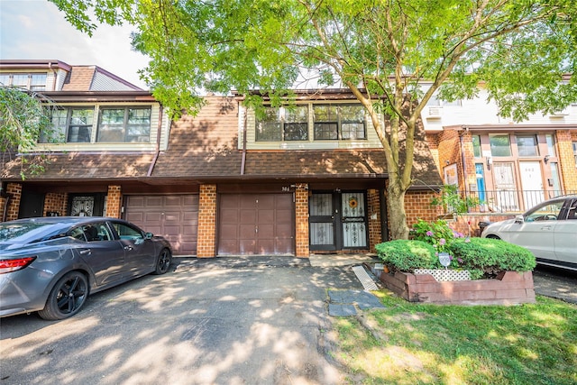 3-06 121st St, College Point, NY 11356 - view of property featuring driveway, brick siding, an attached garage, and a shingled roof