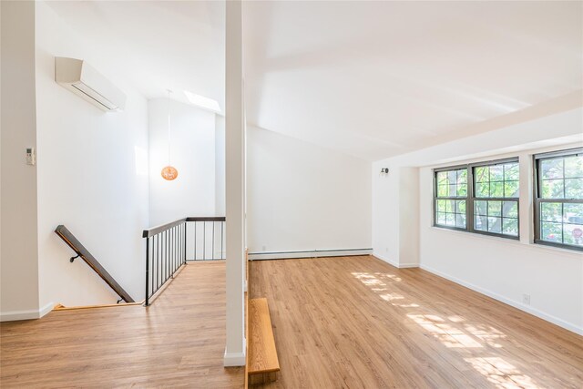 3-06 121st St, College Point, NY 11356 - unfurnished room featuring a baseboard radiator, vaulted ceiling, wood finished floors, and an AC wall unit