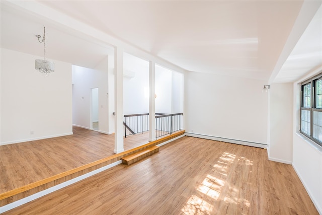 3-06 121st St, College Point, NY 11356 - empty room featuring a baseboard heating unit, wood finished floors, and a chandelier