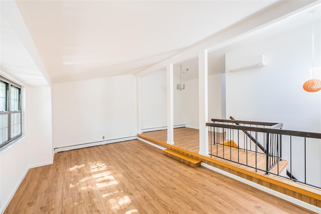3-06 121st St, College Point, NY 11356 - spare room featuring baseboard heating, a wall unit AC, and wood finished floors