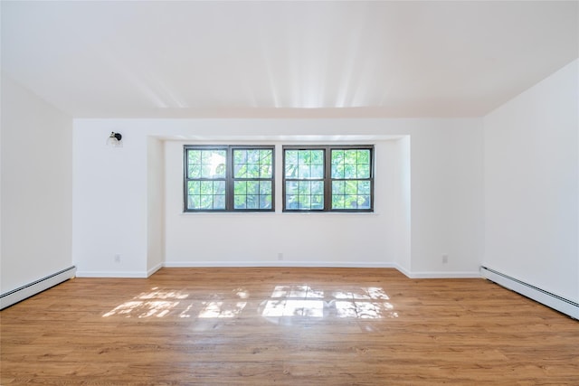 3-06 121st St, College Point, NY 11356 - empty room with healthy amount of natural light, wood finished floors, and a baseboard heating unit