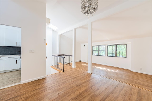 3-06 121st St, College Point, NY 11356 - empty room with a chandelier and light wood-style floors