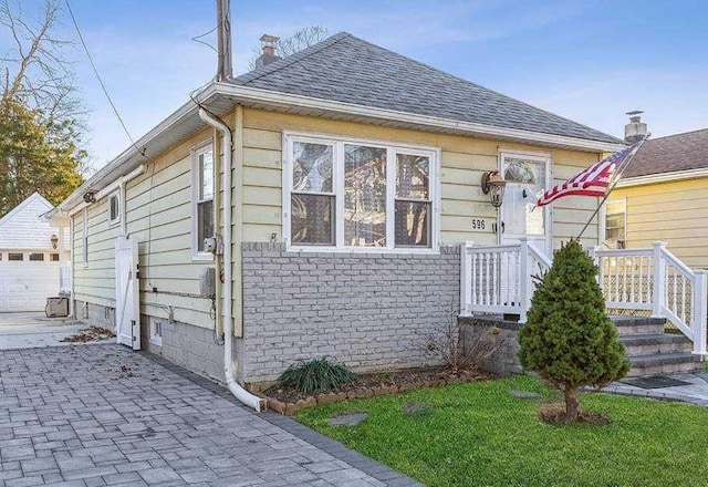 596 Lincoln Ave, West Hempstead, NY 11552 - view of front of home featuring a shingled roof, driveway, and an outbuilding