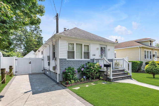 596 Lincoln Ave, West Hempstead, NY 11552 - view of front of home with a gate, roof with shingles, and stone siding