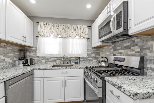 596 Lincoln Ave, West Hempstead, NY 11552 - kitchen featuring stainless steel appliances, backsplash, white cabinetry, and light stone counters