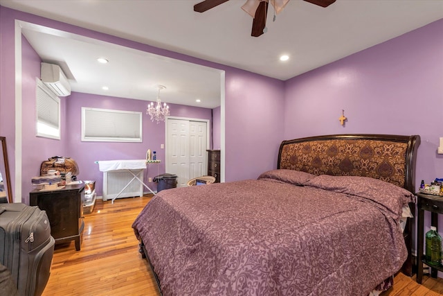 596 Lincoln Ave, West Hempstead, NY 11552 - bedroom with a wall mounted air conditioner, light wood-type flooring, a chandelier, a closet, and a ceiling fan