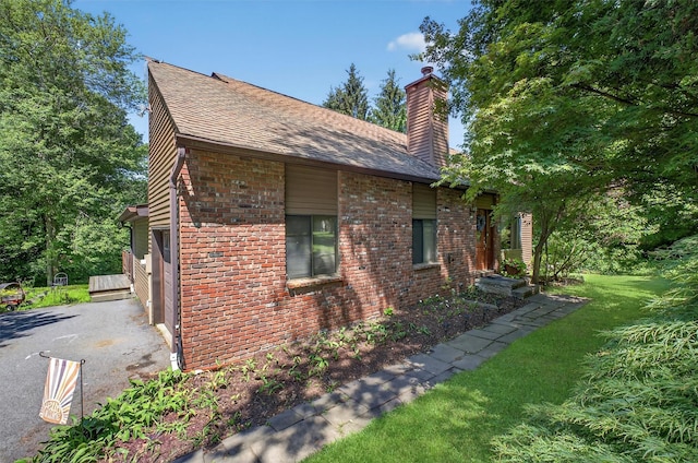 53 Mountain View Dr, Holmes, NY 12531 - view of side of home featuring a chimney, brick siding, a yard, and roof with shingles