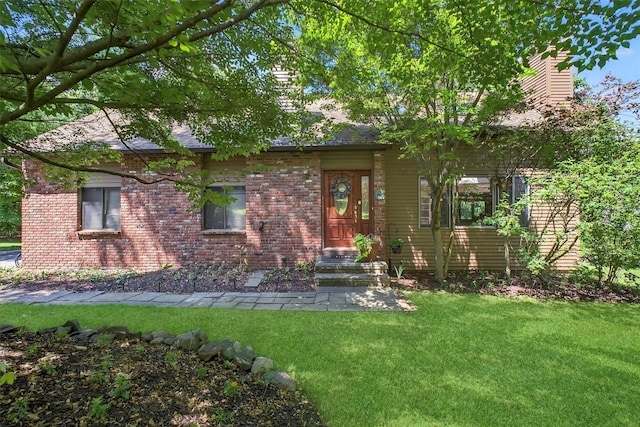 53 Mountain View Dr, Holmes, NY 12531 - view of front of home featuring a front yard, brick siding, a shingled roof, and a chimney