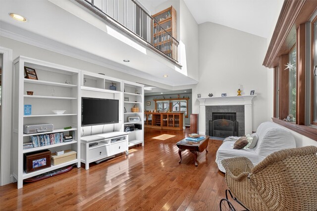 53 Mountain View Dr, Holmes, NY 12531 - living room with wood finished floors, a tile fireplace, a towering ceiling, ornamental molding, and recessed lighting