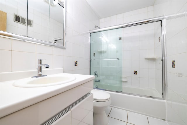 3458 Frederick St, Oceanside, NY 11572 - bathroom featuring tile walls, vanity, bath / shower combo with glass door, and tile patterned floors