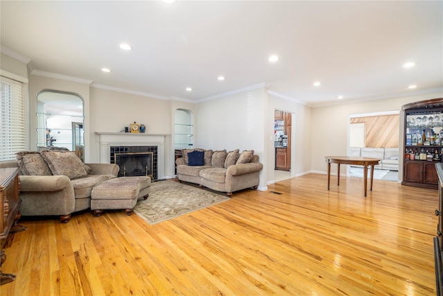 3458 Frederick St, Oceanside, NY 11572 - living room with light wood finished floors, arched walkways, recessed lighting, a tiled fireplace, and ornamental molding
