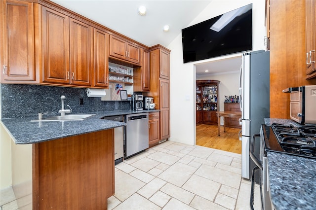 3458 Frederick St, Oceanside, NY 11572 - kitchen featuring stainless steel dishwasher, brown cabinetry, tasteful backsplash, lofted ceiling, and a peninsula