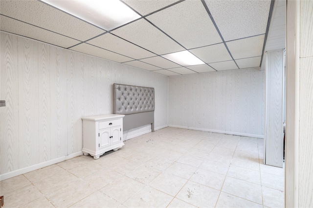 3458 Frederick St, Oceanside, NY 11572 - empty room featuring a paneled ceiling, wood walls, and light tile patterned flooring