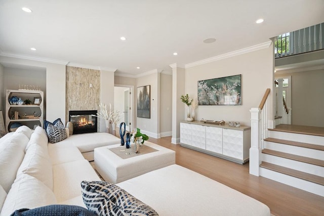 46 Plainview Rd, Woodbury, NY 11797 - living area with light wood-type flooring, recessed lighting, a large fireplace, crown molding, and stairs