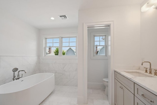46 Plainview Rd, Woodbury, NY 11797 - bathroom featuring a freestanding tub, marble look tiles, vanity, and recessed lighting