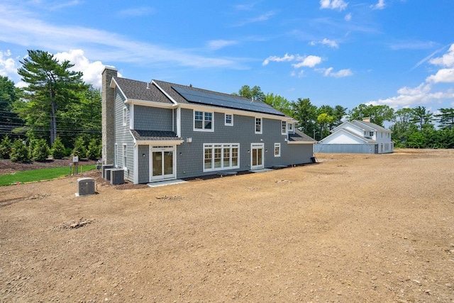 46 Plainview Rd, Woodbury, NY 11797 - back of house with a chimney and roof mounted solar panels