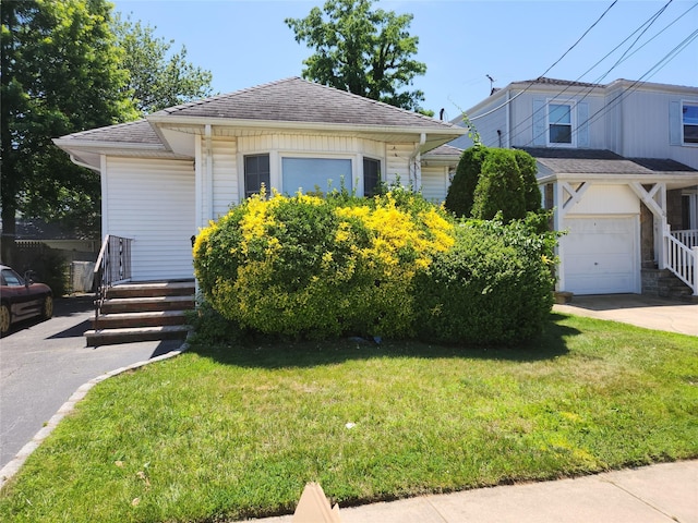 14 W Argyle St, Valley Stream, NY 11580 - view of front of home with a garage, a front yard, roof with shingles, and concrete driveway