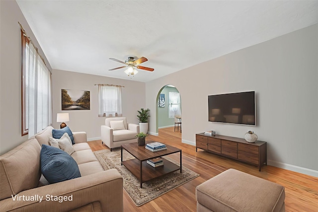 8624 253rd St, Bellerose, NY 11426 - living room featuring arched walkways, ceiling fan, and light wood-style flooring