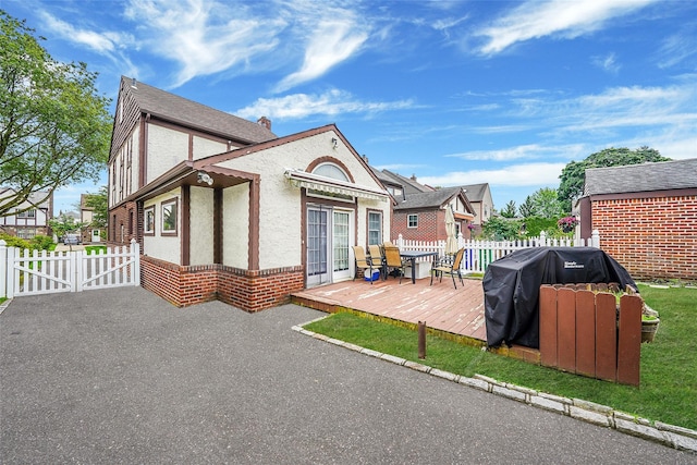 8624 253rd St, Bellerose, NY 11426 - rear view of house featuring a deck, stucco siding, and a gate