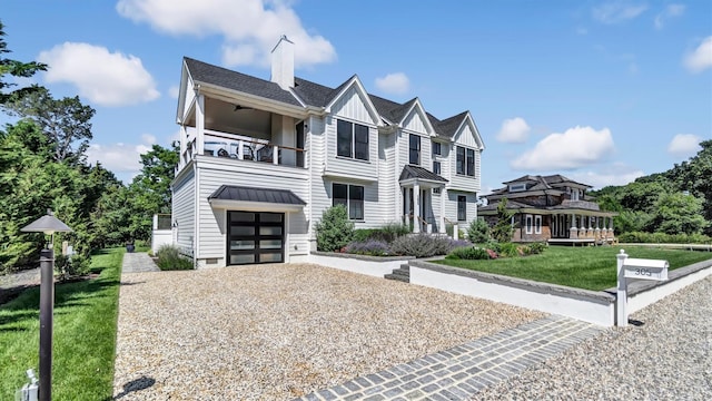 305 Fay Ct, Mattituck, NY 11952 - view of property featuring a balcony, board and batten siding, a garage, gravel driveway, and a front yard