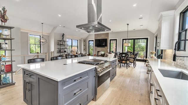 305 Fay Ct, Mattituck, NY 11952 - kitchen with island exhaust hood, high end stainless steel range oven, gray cabinetry, lofted ceiling, and light countertops