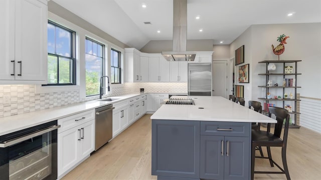 305 Fay Ct, Mattituck, NY 11952 - kitchen with stainless steel appliances, beverage cooler, a kitchen breakfast bar, tasteful backsplash, and white cabinets