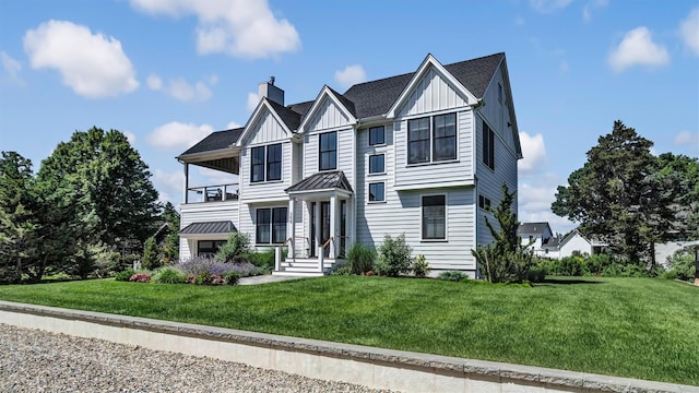 305 Fay Ct, Mattituck, NY 11952 - view of front of property featuring a balcony, board and batten siding, a front yard, and a chimney