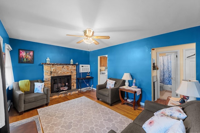 1 Horton Rd, Valley Stream, NY 11581 - living area with ceiling fan, wood finished floors, a stone fireplace, an AC wall unit, and washer / clothes dryer