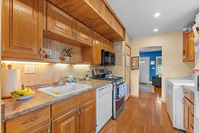 1 Horton Rd, Valley Stream, NY 11581 - kitchen with black microwave, range with two ovens, white dishwasher, independent washer and dryer, and backsplash