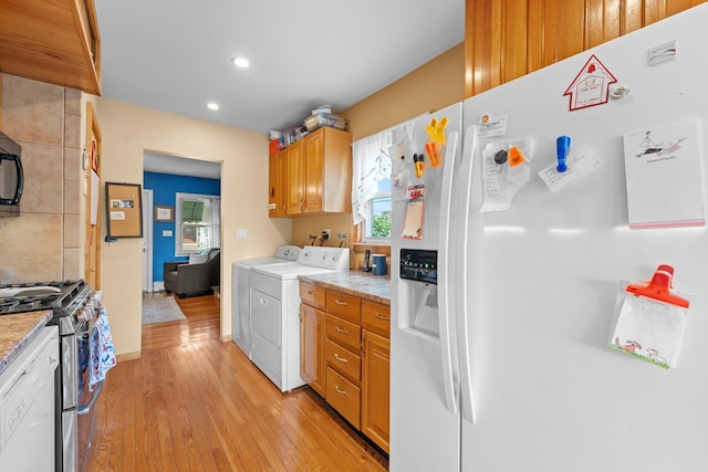 1 Horton Rd, Valley Stream, NY 11581 - kitchen featuring white fridge with ice dispenser, stainless steel range with gas stovetop, washing machine and dryer, light wood-style floors, and recessed lighting