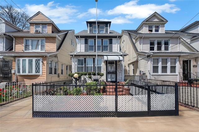 12605 109th Ave, Richmond Hill S, NY 11420 - american foursquare style home featuring a fenced front yard, stone siding, and a shingled roof