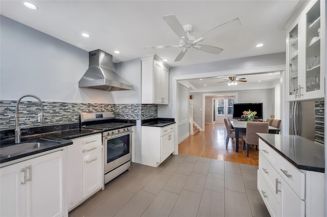 12605 109th Ave, Richmond Hill S, NY 11420 - kitchen featuring wall chimney range hood, stainless steel gas stove, dark countertops, backsplash, and glass insert cabinets