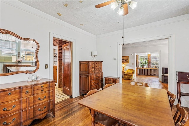 16608 Cryders Ln, Beechhurst, NY 11357 - dining space with radiator, ceiling fan, wood finished floors, a textured ceiling, and ornamental molding