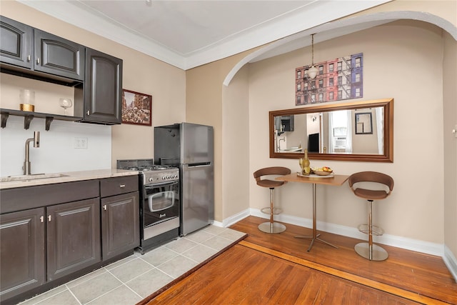 160-15 Powells Cove Blvd Unit A1, Whitestone, NY 11357 - kitchen featuring arched walkways, stainless steel appliances, light wood-style floors, light countertops, and open shelves