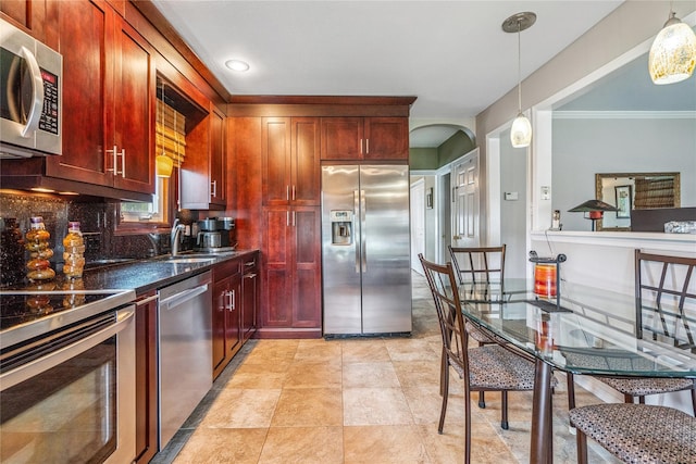 1334 Thompson Dr, Bay Shore, NY 11706 - kitchen with appliances with stainless steel finishes, dark brown cabinets, crown molding, hanging light fixtures, and arched walkways