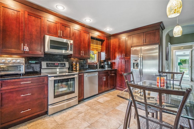 1334 Thompson Dr, Bay Shore, NY 11706 - kitchen with appliances with stainless steel finishes, decorative backsplash, reddish brown cabinets, plenty of natural light, and recessed lighting