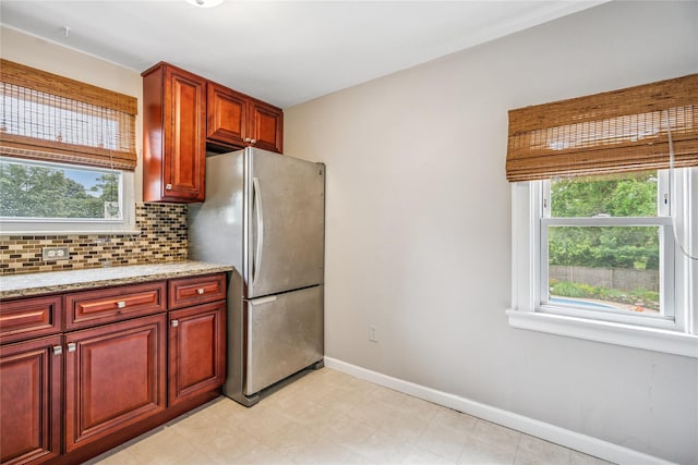 1334 Thompson Dr, Bay Shore, NY 11706 - kitchen with freestanding refrigerator, backsplash, light stone countertops, light flooring, and dark brown cabinets