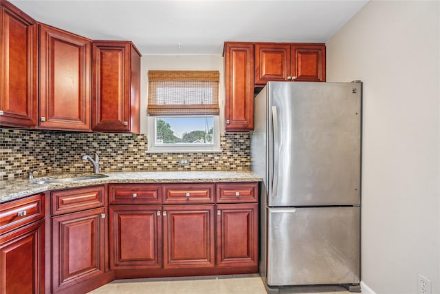 1334 Thompson Dr, Bay Shore, NY 11706 - kitchen featuring freestanding refrigerator, reddish brown cabinets, backsplash, and light stone counters