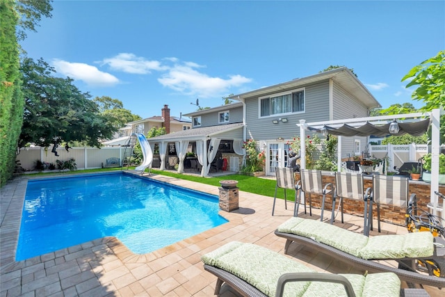 318 Claremont Ave, West Babylon, NY 11704 - view of pool with a water slide, a pergola, a fenced backyard, and a patio area