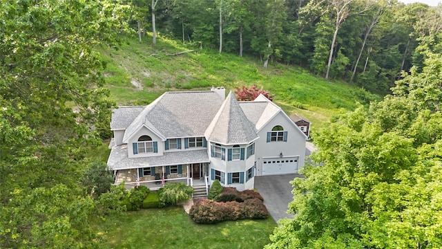 8 Hamlet Way, Hopewell Junction, NY 12533 - view of front facade featuring a porch, driveway, a shingled roof, a view of trees, and stucco siding