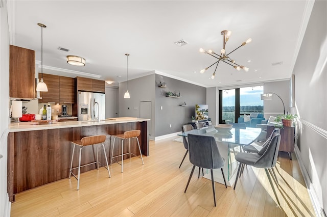 701 Rdg Hill Blvd Unit 10B, Yonkers, NY 10710 - dining space featuring light wood finished floors, a chandelier, and crown molding