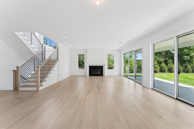 135 S Rd, Westhampton, NY 11977 - unfurnished living room featuring light wood-style flooring, stairs, and a glass covered fireplace