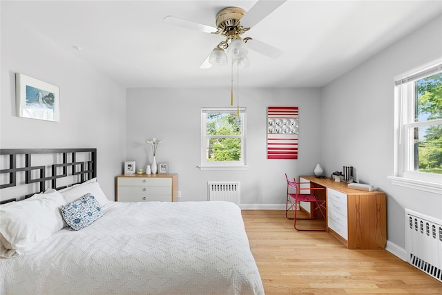 107 California Ave, Freeport, NY 11520 - bedroom featuring radiator heating unit, light wood finished floors, and ceiling fan