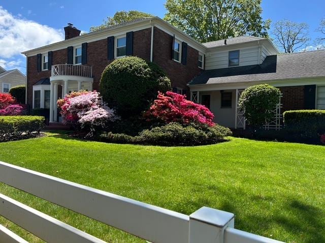 107 California Ave, Freeport, NY 11520 - view of front of house featuring a chimney, a front lawn, and brick siding