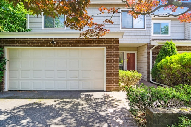 31 Boathouse Ln E, Bay Shore, NY 11706 - view of front of home featuring brick siding, an attached garage, and asphalt driveway