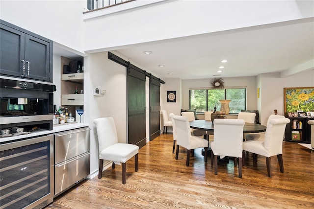 31 Boathouse Ln E, Bay Shore, NY 11706 - dining space with beverage cooler, a barn door, light wood-style flooring, a dry bar, and recessed lighting