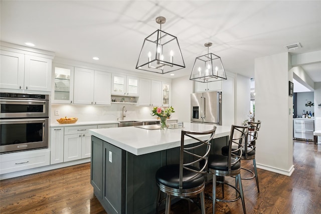 31 Boathouse Ln E, Bay Shore, NY 11706 - kitchen featuring stainless steel appliances, light countertops, dark wood-type flooring, a center island, and recessed lighting