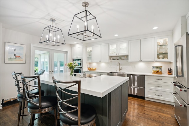 31 Boathouse Ln E, Bay Shore, NY 11706 - kitchen featuring appliances with stainless steel finishes, light countertops, white cabinets, recessed lighting, and a kitchen island