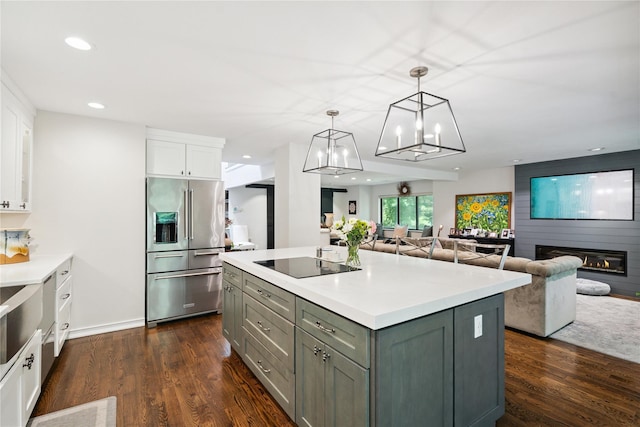 31 Boathouse Ln E, Bay Shore, NY 11706 - kitchen featuring high end refrigerator, black electric stovetop, white cabinets, a center island, and dark wood-style floors
