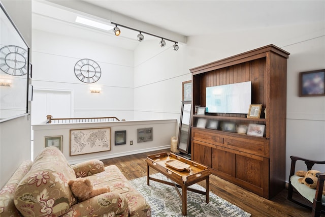 31 Boathouse Ln E, Bay Shore, NY 11706 - living area featuring rail lighting, wood finished floors, and vaulted ceiling